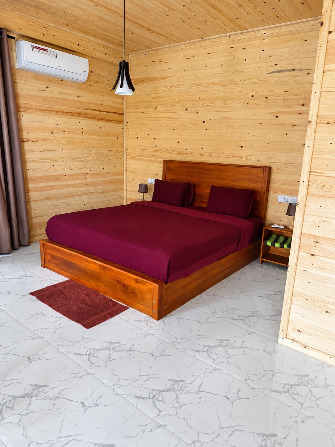 Double bed and warm wooden walls in a Country Homes room