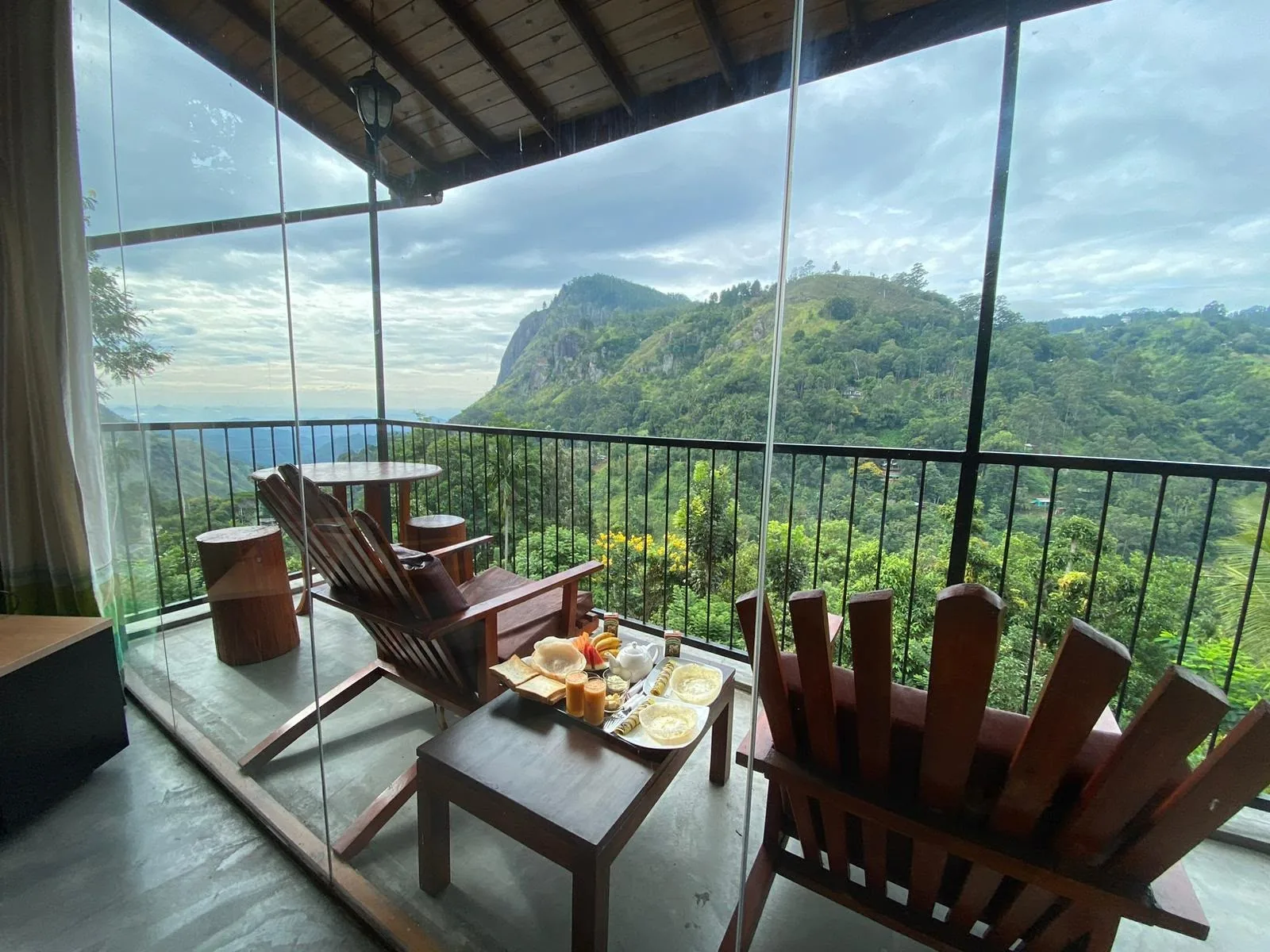 Balcony chairs and a breakfast table with the mountains beyond